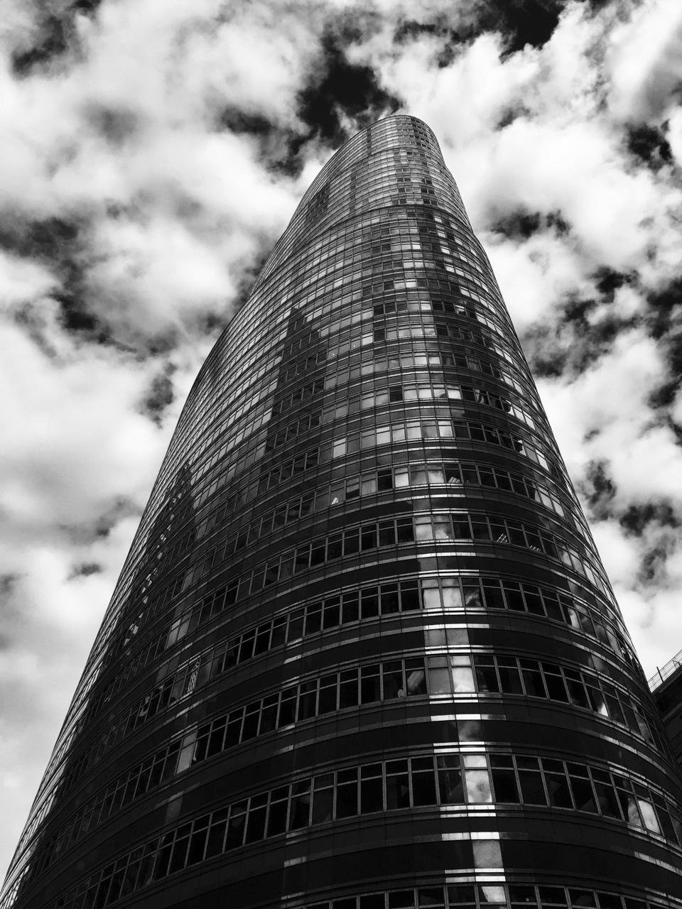 Looking up at the lipstick building at 855 3rd ave. New York, NY. designed by John Burgee Architects with Philip Johnson. black and white image with dramatic cloudscape