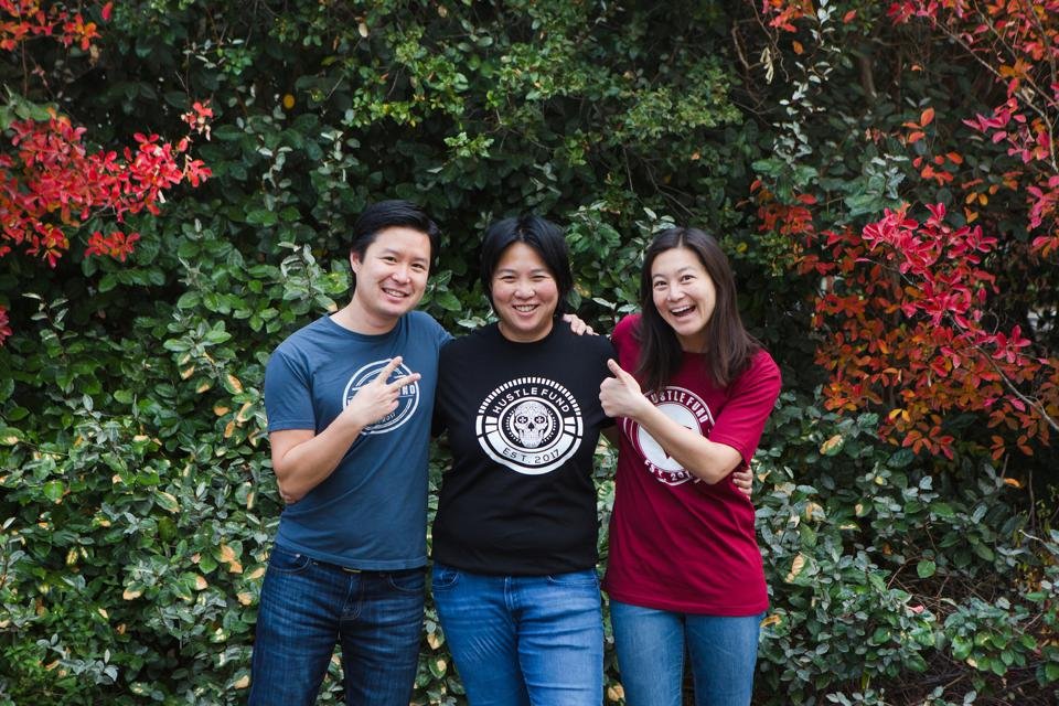 Three general partners at a venture capital firm standing in front of a lush background. 