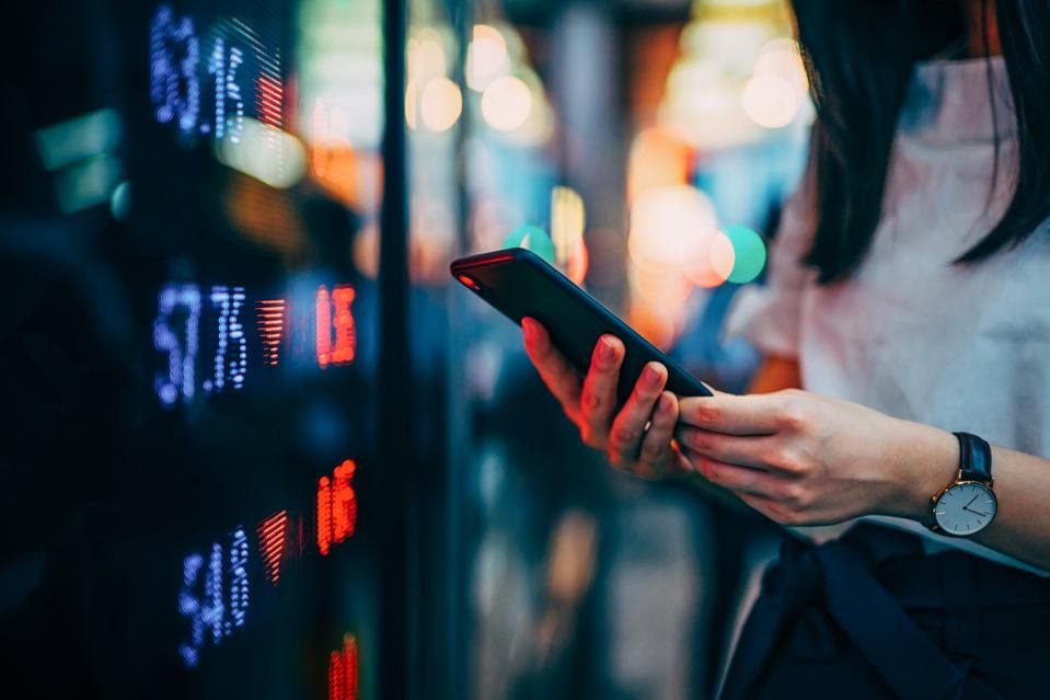 Businesswoman checking financial trading data on smartphone