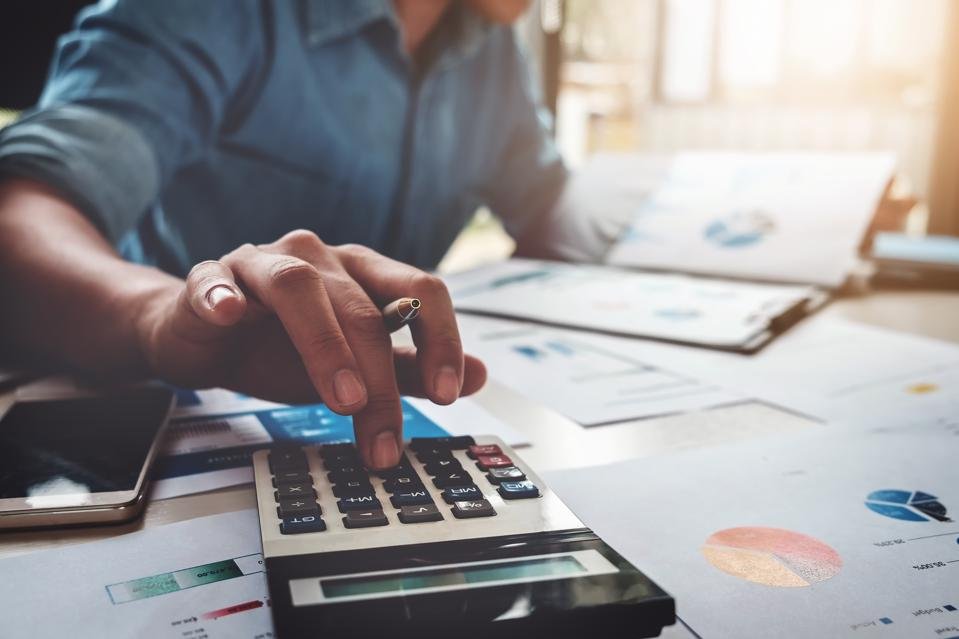 Businessman using calculator and analyzing financial charts